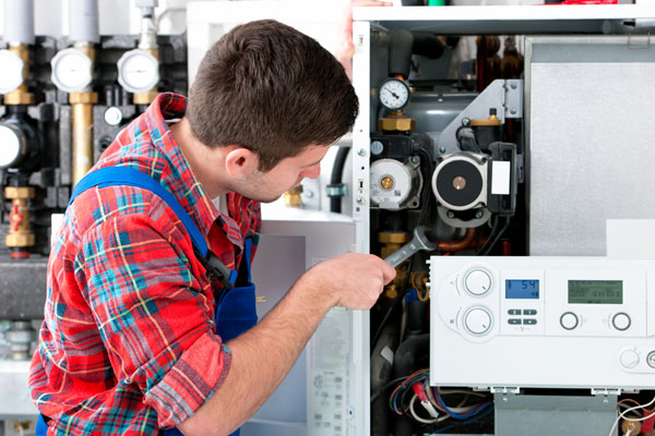 HVAC technician inspecting and repairing boiler controls in Longmont