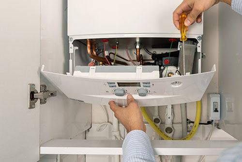 HVAC technician repairing an indoor boiler in Longmont