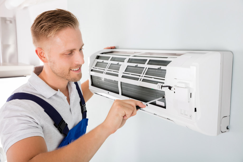 HVAC technician performing ductless air conditioning maintenance in Longmont
