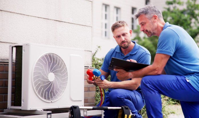 HVAC technicians installing an outdoor air conditioning unit in Longmont