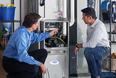 HVAC technician explaining furnace repair and maintenance to a homeowner in Longmont, CO