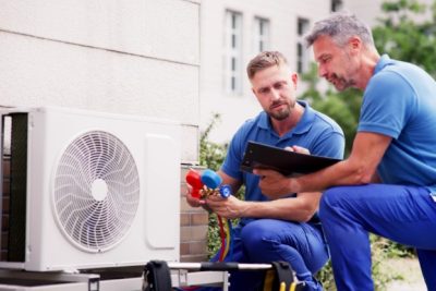 HVAC technicians reviewing an outdoor air conditioning unit in Longmont, CO