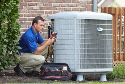 HVAC technician inspecting an outdoor air conditioning unit in Longmont, CO